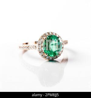 Un magnifique anneau émeraude avec des diamants étincelants isolés sur un fond blanc. Banque D'Images