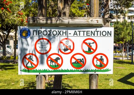 Panneau sur une pelouse pour bronzer sur la promenade de la plage de Limassol, avertissement que l'irrigation est effectuée ici avec des eaux usées traitées. Limassol, Chypre Banque D'Images