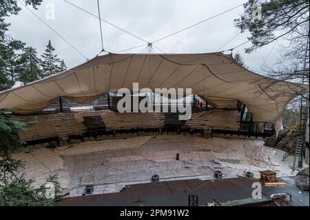 Wunsiedel, Allemagne. 12th avril 2023. Le toit de la tente du Festival de Luisenburg, qui est sur le point d'être achevé, est fixé à des câbles d'acier au-dessus de l'auditorium. Conçu à l'origine par l'architecte Frei Otto, le toit de tente de 1600 mètres carrés est surélevé au-dessus de l'auditorium du théâtre du festival. Credit: Daniel Vogl/dpa/Alay Live News Banque D'Images