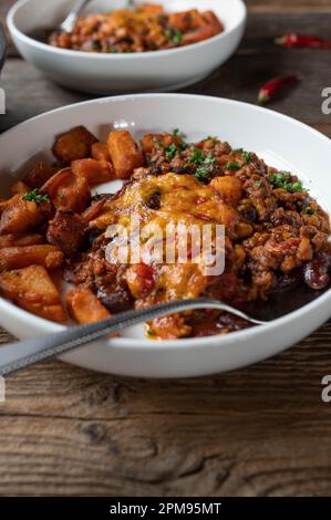 Ragoût de haricots mexicains avec croûte de fromage cheddar et patates douces Banque D'Images