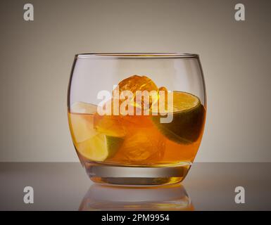 Cocktail de whisky dans un verre à verre frais avec glace et segment d'agrumes. Banque D'Images