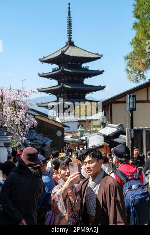 Kyoto, Japon - 28 mars 2023: Un couple vêtu de kimonos prendre un selfie sur Sannenzaka, une rue piétonne pavée à Kyoto, Japon. Banque D'Images