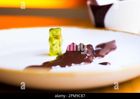Des ours délicieux jouant sur une table de nourriture avec de la sauce au chocolat. Banque D'Images