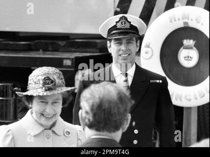 La reine Elizabeth II parle avec des responsables surveillés par son fils, le prince Andrew, duc de York, à son arrivée à Portsmouth, en Angleterre, à bord du HMS Invincible après avoir servi dans la guerre des Malouines comme pilote d'hélicoptère. Crédit : Rob Taggart/Alamy Banque D'Images