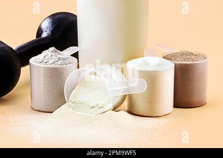 petit-lait ou tremblement de caséine, smoothie de lactosérum avec barre de chocolat de protéine, haltères d'entraînement de poids sur le côté, mélange de créatine pour la prise de masse musculaire Banque D'Images