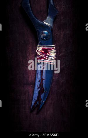 ciseaux anciens reliés dans le sang sur un fond en bois Banque D'Images