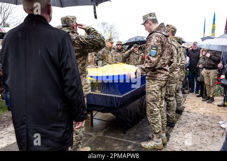 Les militaires saluent et tiennent le drapeau ukrainien par le cercueil lors des funérailles d'Evgeny Yakovlev, 42 ans, un soldat tué par les forces russes sur le front ukrainien oriental dans un combat, sur le cimetière de Lisove à Kiev, la capitale de l'Ukraine sur 12 avril 2023. Le cimetière de Lisove est où la plupart des militaires tombés de Kiev sont enterrés. Comme l'invasion à grande échelle de l'Ukraine par les forces russes continue, la lutte dans l'est de l'Ukraine provoque un taux de victimes très élevé, bien que les chiffres exacts soient inconnus. L'Ukraine se prépare à une offensive de printemps pour reprendre les terres occupées par la Russie. (Photo par Dominika Zarzycka Banque D'Images