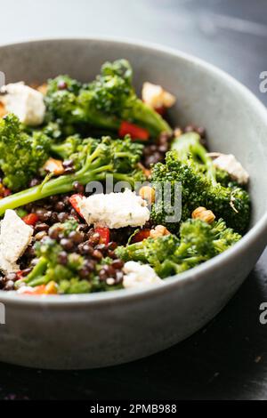 Lentilles marinées avec brocoli et feta vegan. Banque D'Images