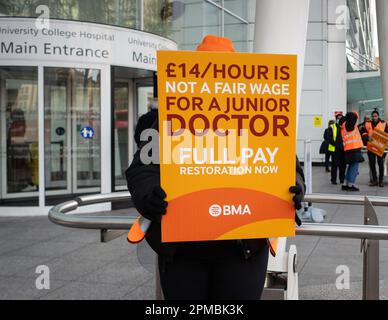 Un médecin junior tient une bannière de protestation devant le University College Hospital de Londres, lors d'une grève des médecins pour une augmentation de salaire, avril - 2023. Banque D'Images