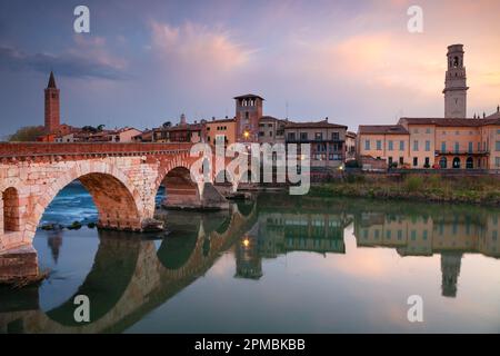 Vérone, Italie. Image de paysage urbain de la belle ville italienne de Vérone avec le pont de pierre au-dessus de la rivière Adige au coucher du soleil. Banque D'Images