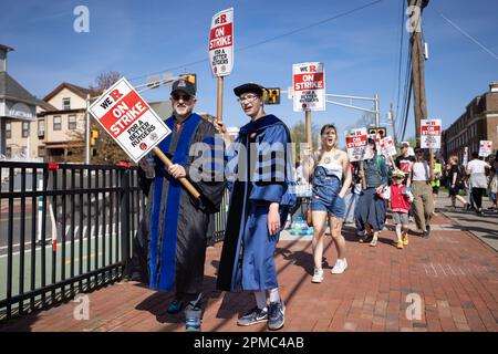 NOUVEAU-BRUNSWICK, NEW JERSEY - 12 AVRIL : deux professeurs de Rutgers défilent dans leurs robes tout en participant à une grève sur le campus principal de l'université, à 12 avril 2023, au Nouveau-Brunswick, dans le New Jersey. Les trois syndicats de professeurs représentant environ 9 000 travailleurs de l'université Rutgers, l'université d'État du New Jersey, ont été en grève après avoir omis de conclure un contrat dans le cadre des négociations avec l'administration du président de Rutgers, Jonathan Holloway. Le walkout est le premier de l'histoire de 257 ans de l'université publique et suit près d'une année de négociation pour l'augmentation des salaires et de meilleurs contrats.(photo Banque D'Images