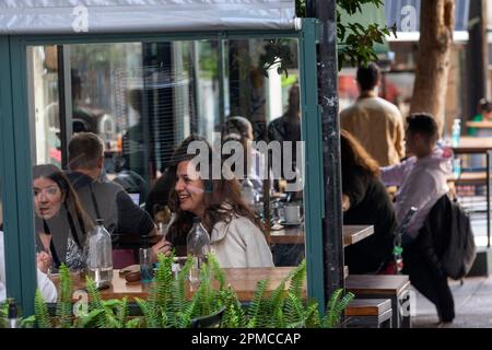 Athènes, Grèce. 11th avril 2023. Les gens passent du temps dans un café local du centre-ville d'Athènes, en Grèce, sur 11 avril 2023. La rencontre autour d'une tasse de café fait depuis longtemps partie intégrante de la culture grecque. Toutefois, la pression inflationniste de l'année dernière a forcé 54 pour cent des amateurs de café à réduire leur consommation de caféine, a constaté une récente enquête menée pour l'Association hellénique du café. Crédit: Marios Lolos/Xinhua/Alamy Live News Banque D'Images