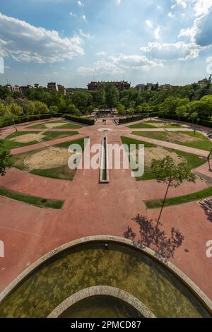 Grande place avec fontaines, ciment rouge, et des portions d'herbe dans un parc urbain Banque D'Images