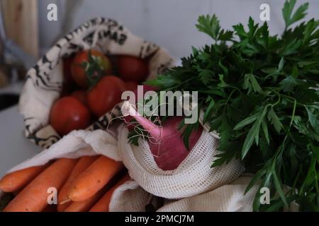 Épicerie saine shopping, légumes, fruits et légumes verts dans un sac écologique sur le comptoir de cuisine. Banque D'Images