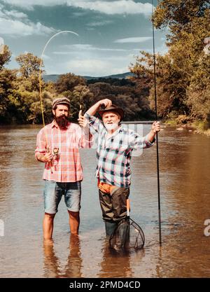 Passe-temps masculin. L'homme barbu et son père pêchent ensemble. Commencez à vivre. Pêcheur avec canne à pêche. Bon profit. Deux pêcheurs se détendent tout en pêchant sur le Banque D'Images