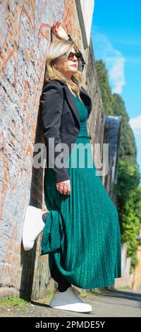 Femme blonde mature avec lunettes de soleil posant. Banque D'Images