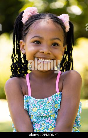 Gros plan portrait d'afro-américaine souriante petite fille avec des dreadlocks regardant loin Banque D'Images