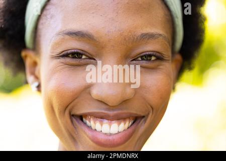 Portrait en gros plan d'une femme mi-adulte afro-américaine souriante dans le parc Banque D'Images