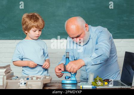 École. Ancien professeur barbu dans la salle de classe. Mon expérience de microbiologie. Professeur drôle dans la salle de classe. Enfant de l'école primaire. Science. Retour à Banque D'Images