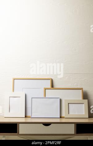 Verticale de cinq cadres vides différents avec espace de copie sur la table contre le mur blanc Banque D'Images