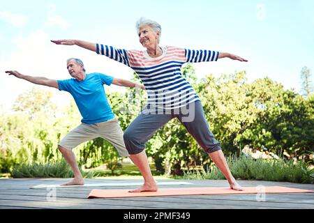 Le yoga pose des yogis de tous âges. un couple senior faisant du yoga ensemble à l'extérieur. Banque D'Images