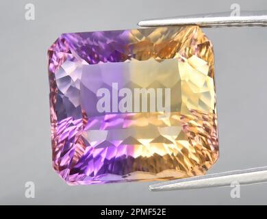 Pierre précieuse naturelle jaune violet amétrine sur fond gris. Variété de quartz violet Banque D'Images