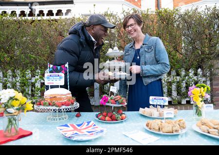 Sarah Mountcastle, une résidente locale, et Ainsley Harriott, chef de la télévision Celebrity, avec un spread de couronnement lorsqu'il participe au « Big Knock ». Il se joint aux organisateurs du grand déjeuner de Coronation qui frappent à l'est de Shen, dans le sud-ouest de Londres, pour inviter la communauté à se réunir à la fête de rue sur 7 mai. Date de la photo: Jeudi 13 avril 2023. Banque D'Images