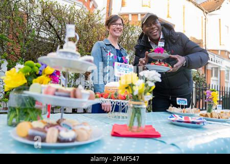 Sarah Mountcastle, une résidente locale, et Ainsley Harriott, chef de la télévision Celebrity, avec un spread de couronnement lorsqu'il participe au « Big Knock ». Il se joint aux organisateurs du grand déjeuner de Coronation qui frappent à l'est de Shen, dans le sud-ouest de Londres, pour inviter la communauté à se réunir à la fête de rue sur 7 mai. Date de la photo: Jeudi 13 avril 2023. Banque D'Images