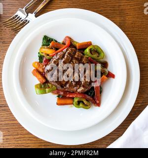 Steak de bœuf grillé et légumes sur une assiette blanche. Steak de bœuf grillé avec sauce. Banque D'Images