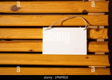 affiche d'image suspendue blanche sur les lamelles de chaise en bois doré avec espace libre vide pour le gabarit ou la zone de copie vierge Banque D'Images