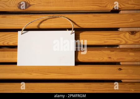 affiche d'image suspendue blanche sur les lamelles de chaise en bois doré avec espace libre vide pour le gabarit ou la zone de copie vierge Banque D'Images