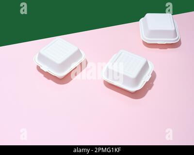 Emballage écologique pour la livraison des aliments. Boîtes à emporter hamburger sur fond vert et rose Banque D'Images