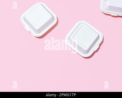 Emballage écologique pour la livraison des aliments. Boîtes à emporter hamburger sur fond vert et rose Banque D'Images
