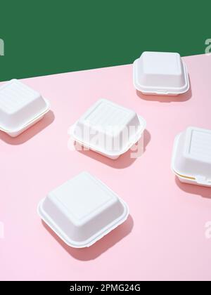 Emballage écologique pour la livraison des aliments. Boîtes à emporter hamburger sur fond vert et rose Banque D'Images