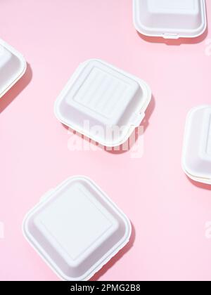 Emballage écologique pour la livraison des aliments. Boîtes à emporter hamburger sur fond vert et rose Banque D'Images