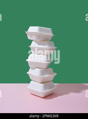 Emballage écologique pour la livraison des aliments. Boîtes à emporter hamburger sur fond vert et rose Banque D'Images