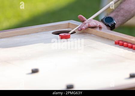 Hommes jouant au jeu de Novus. Novuss est un sport national en Lettonie semblable au billard de poche ou à la piscine. Banque D'Images