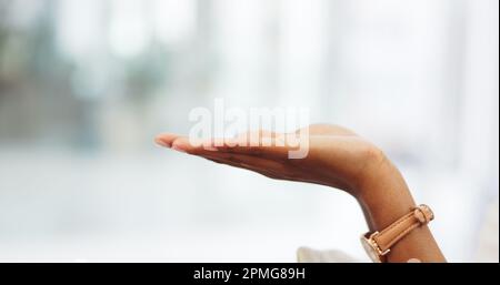 Une femme ouverte à la main montrant un espace de maquette dans la chambre d'un bâtiment moderne. Gros plan d'une fille qui étire sa paume avec un geste de prise ou de prise Banque D'Images