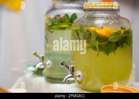 Distributeur de limonade gros plan avec les fruits : pamplemousse, orange, citron. Zone de bienvenue avec boissons aux limonades colorées. Boissons saines sans alcool Banque D'Images