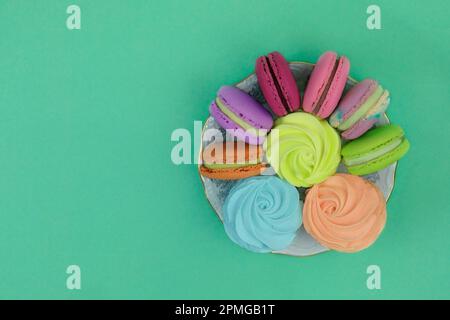 Desserts sucrés traditionnels colorés pour les vacances. Guimauves en plaques sur fond vert. Banque D'Images