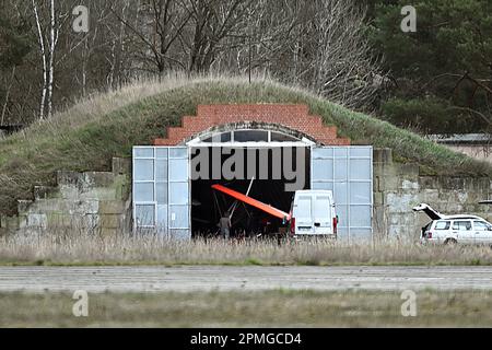 13 avril 2023, Brandebourg, Niedergörsdorf: Derrière la piste, vous pouvez voir un vieux hangar d'avion avec un avion ultraléger. A l'aérodrome 'Altes Lager', il y a eu un accident avec un avion ultraléger. Photo: Michael Bahlo/dpa Banque D'Images