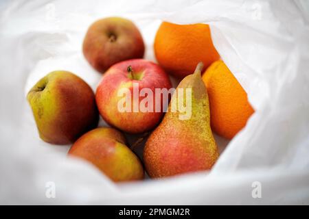 Image symbolique sur le thème de la nutrition et des déchets d'emballage. Les fruits frais sont dans un sac en plastique. Berlin, 13 avril 2023. Banque D'Images