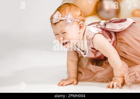 Petite pleurs malheureux redhead bébé fille fête le premier anniversaire. Fête de famille de 1 ans séance photo professionnelle en studio photo. Adora mignon Banque D'Images