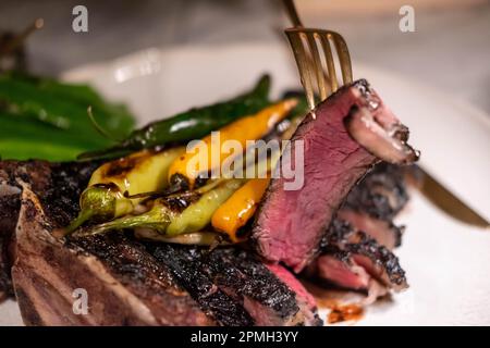 La carne asada, un rôti de bœuf grillé et émincé servi sur une assiette avec des oignons toreado. C'est un plat mexicain. Banque D'Images