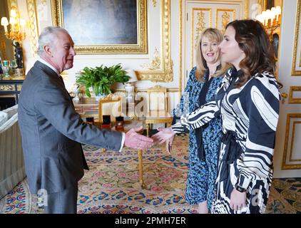 Le roi Charles III salue Anne Jessopp, chef de la direction de la monnaie royale (au centre) et Rebecca Morgan, directrice, avant d'être présentée avec des pièces de monnaie couronnement nouvellement frappées au château de Windsor, dans le Berkshire. Un portrait couronné du roi sera pour la première fois sur une nouvelle gamme de pièces commémoratives créées pour célébrer le prochain couronnement. La collection, qui comprend une pièce de 50p et £5, sera libérée plus tard ce mois-ci avant la célébration historique de 6 mai. Date de la photo: Jeudi 13 avril 2023. Banque D'Images