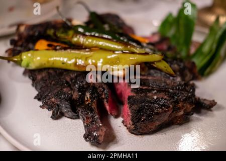 La carne asada, un rôti de bœuf grillé et émincé servi sur une assiette avec des oignons toreado. C'est un plat mexicain. Banque D'Images