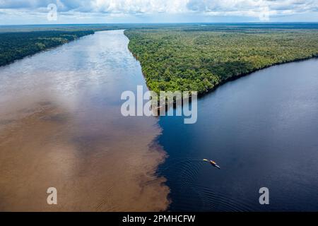 Petit bateau sur le point de rencontre de la rivière Casiquiare et de la rivière noire Pasioni, dans le sud profond du Venezuela, en Amérique du Sud Banque D'Images