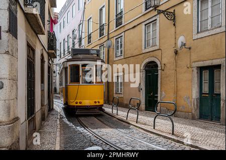 Tramway jaune rétro dans une rue étroite de Lisbonne, Portugal Banque D'Images