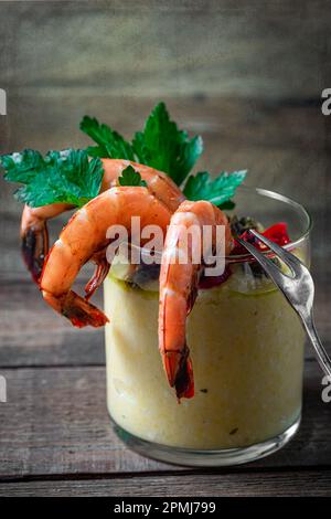 Crevettes cuites à la vapeur dans un petit verre avec polenta. Photo ci-dessus, gros plan. Banque D'Images