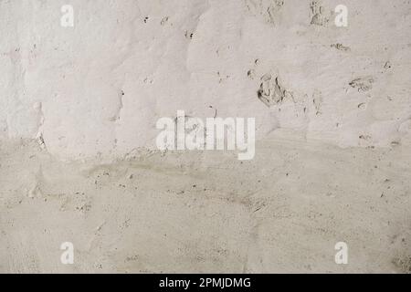 Détail du revêtement de plâtre de rendu de ciment sur l'ancien mur blanc lavé à la chaux Banque D'Images